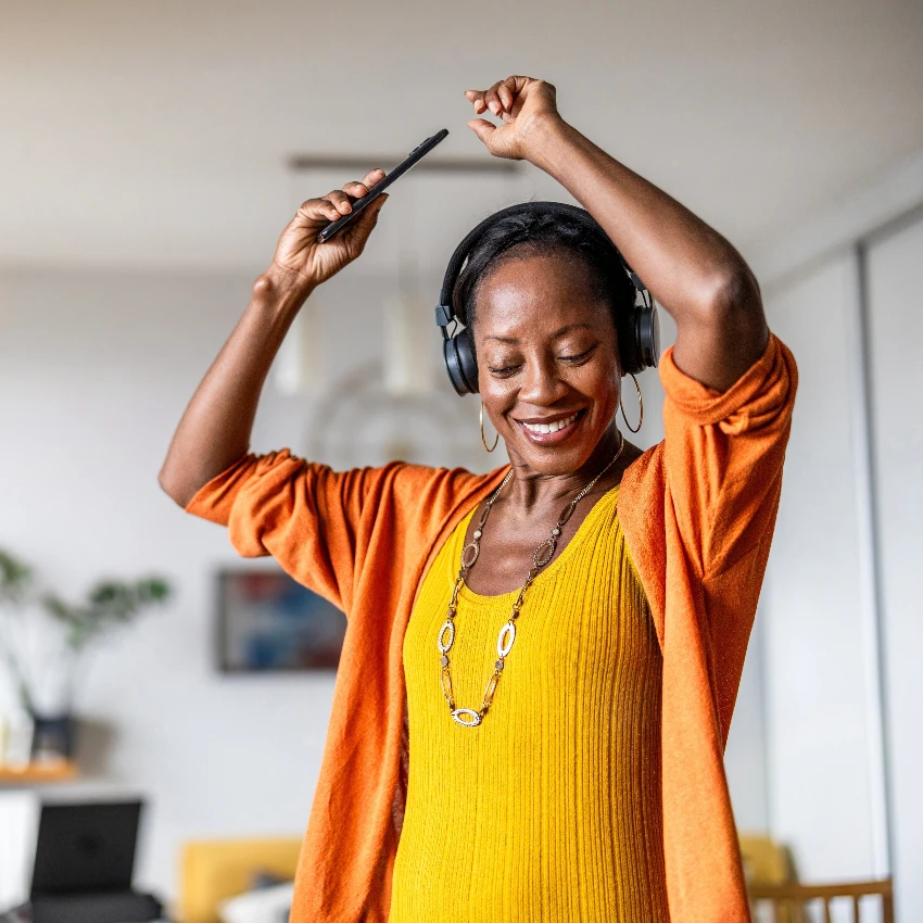 10 pequeños momentos cotidianos que realmente traen alegría a la vida de las personas Mujer alegre escuchando música y bailando