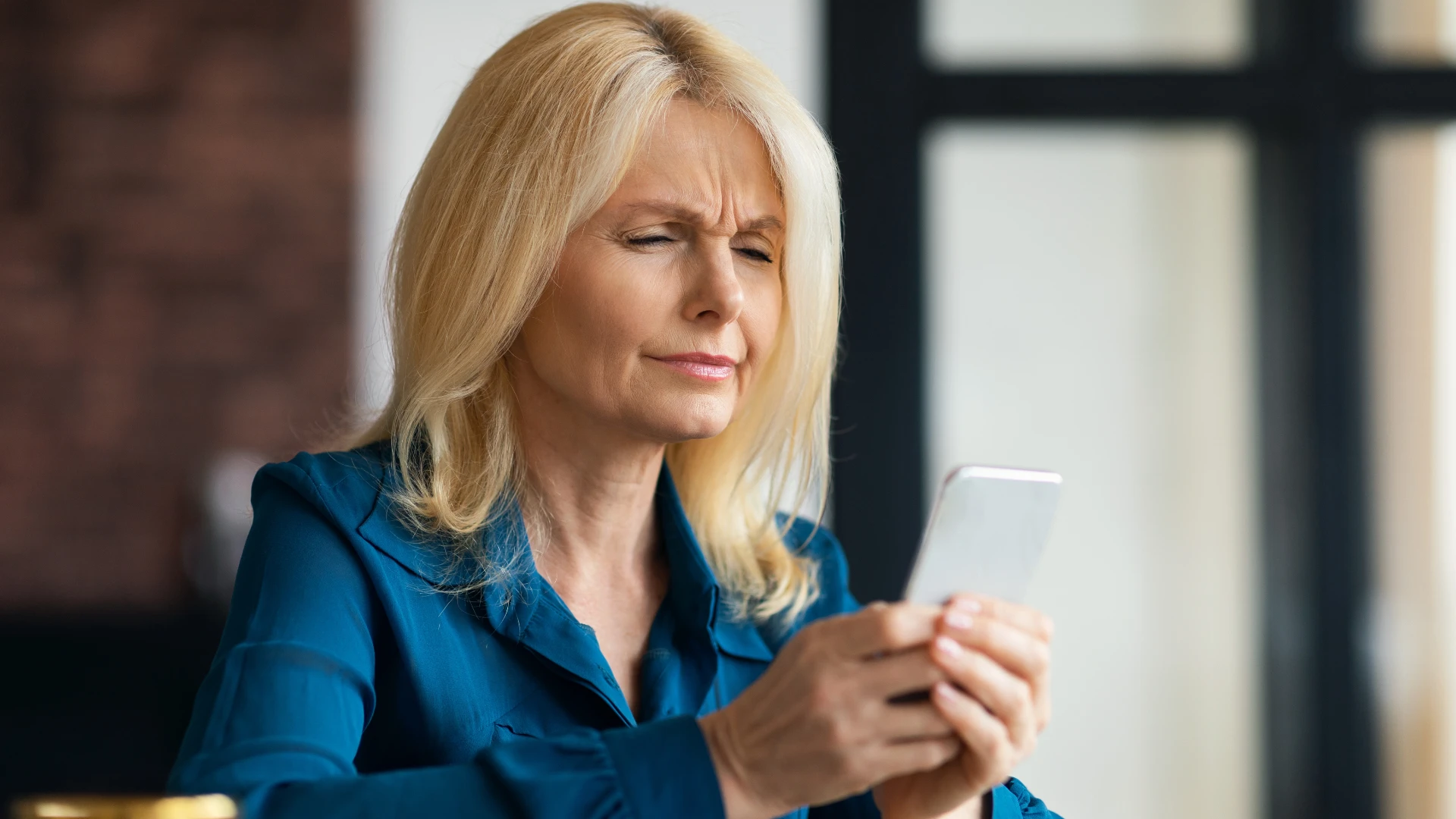 Hechos Críticos que Todos Deben Conocer Mujer escéptica sobre las noticias en su teléfono